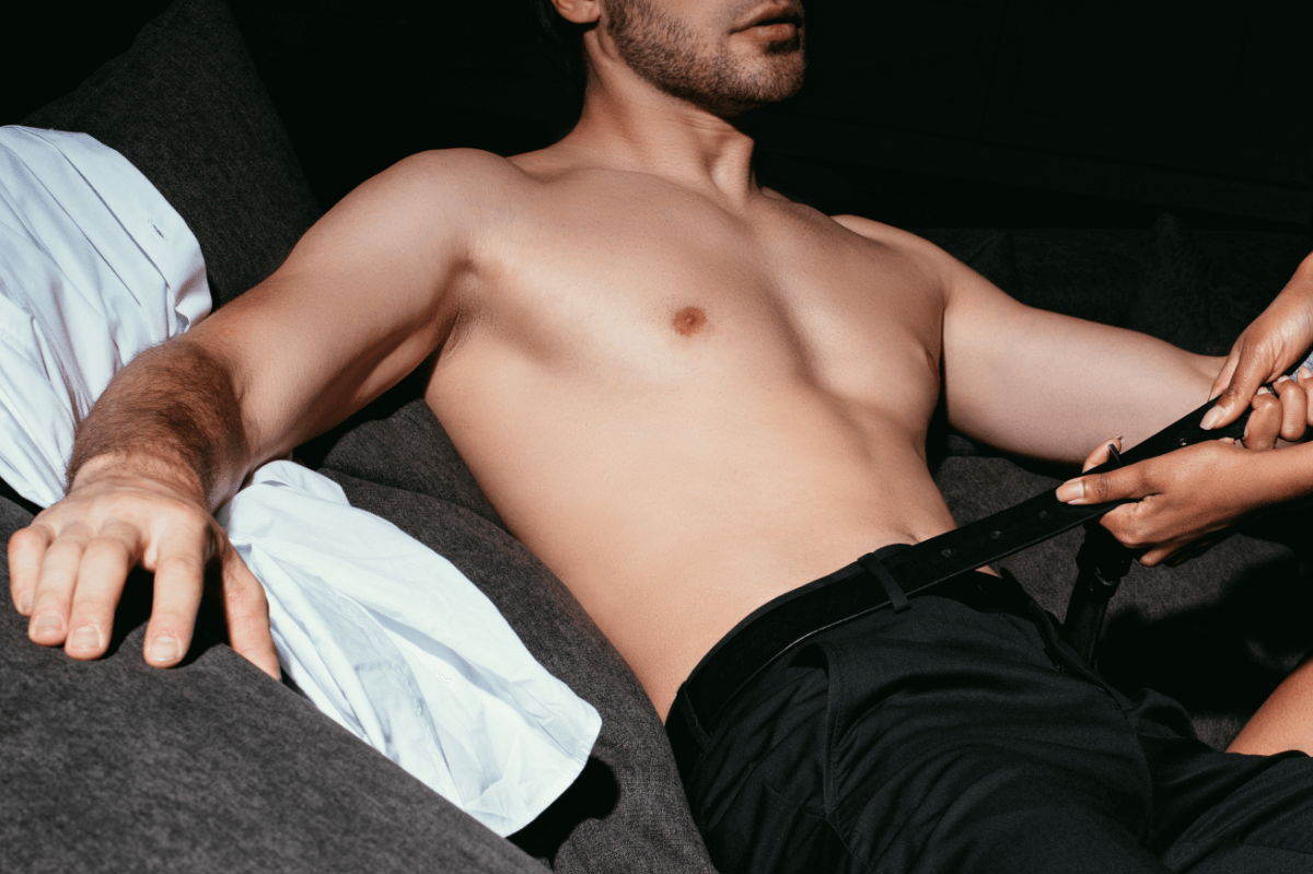 a man lying down on a couch. Somebody is opening his belt. Locktober - Keuschheit im Oktober Locktober - Chastity in October