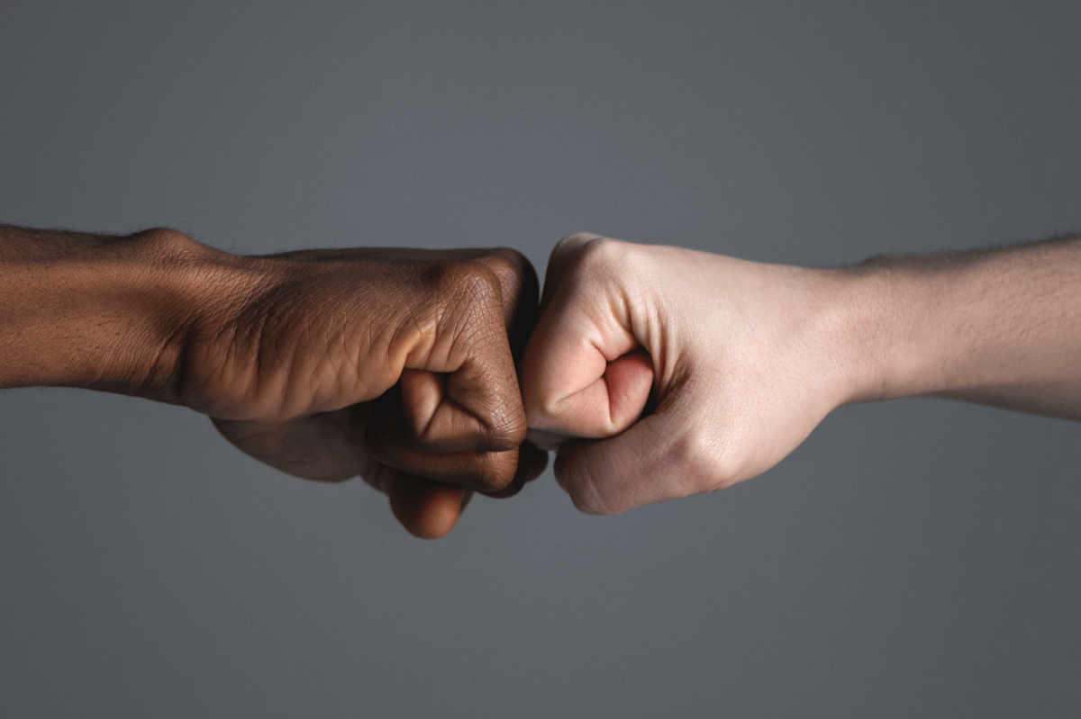 Fisting-Community Infos. Symbolbild: eine hell- und eine dunkelhäutige Faust. Englisch: Fisting community info. Symbolic image: a light-skinned and a dark-skinned fist.