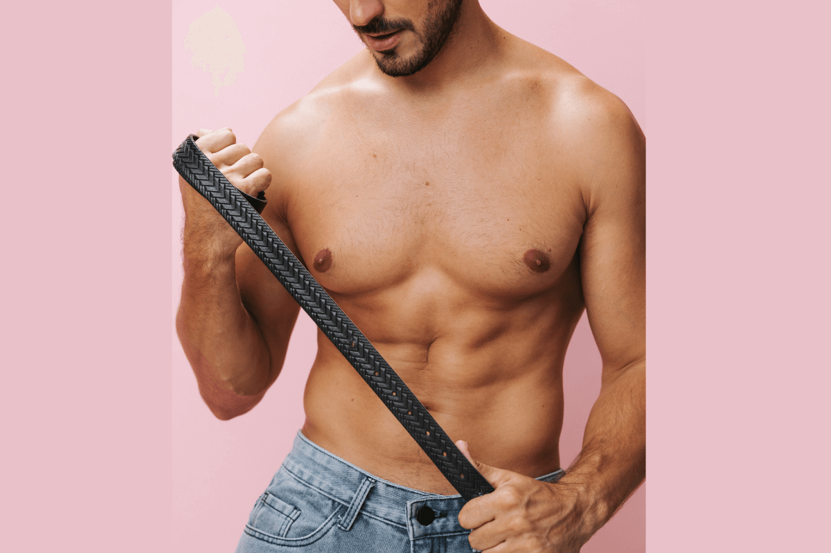 Spanking Positionen und Anleitungen Symbolbild: Mann mit freiem Oberkörper hält einen Gürtel in den Händen. Englisch: Spanking positions and instructions Symbolic image: Man with bare upper body holding a belt in his hands.