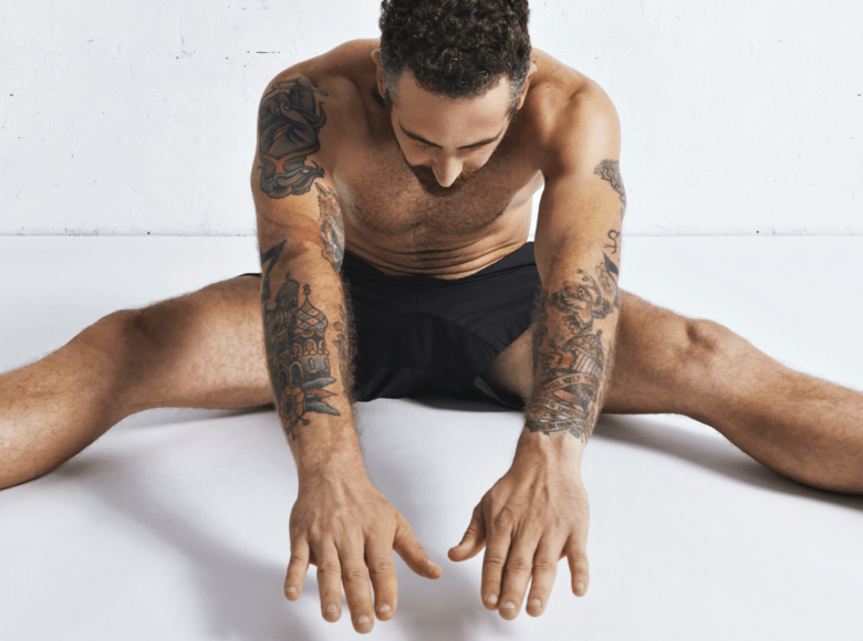 Autofellatio Symbolbild: Ein an den Armen tätowierter Mann, der nur mit Unterhose bekleidet ist, macht Dehnübungen. Englisch: Self-sucking symbol picture: a man tattooed on his arms, wearing only underpants, does stretching exercises.