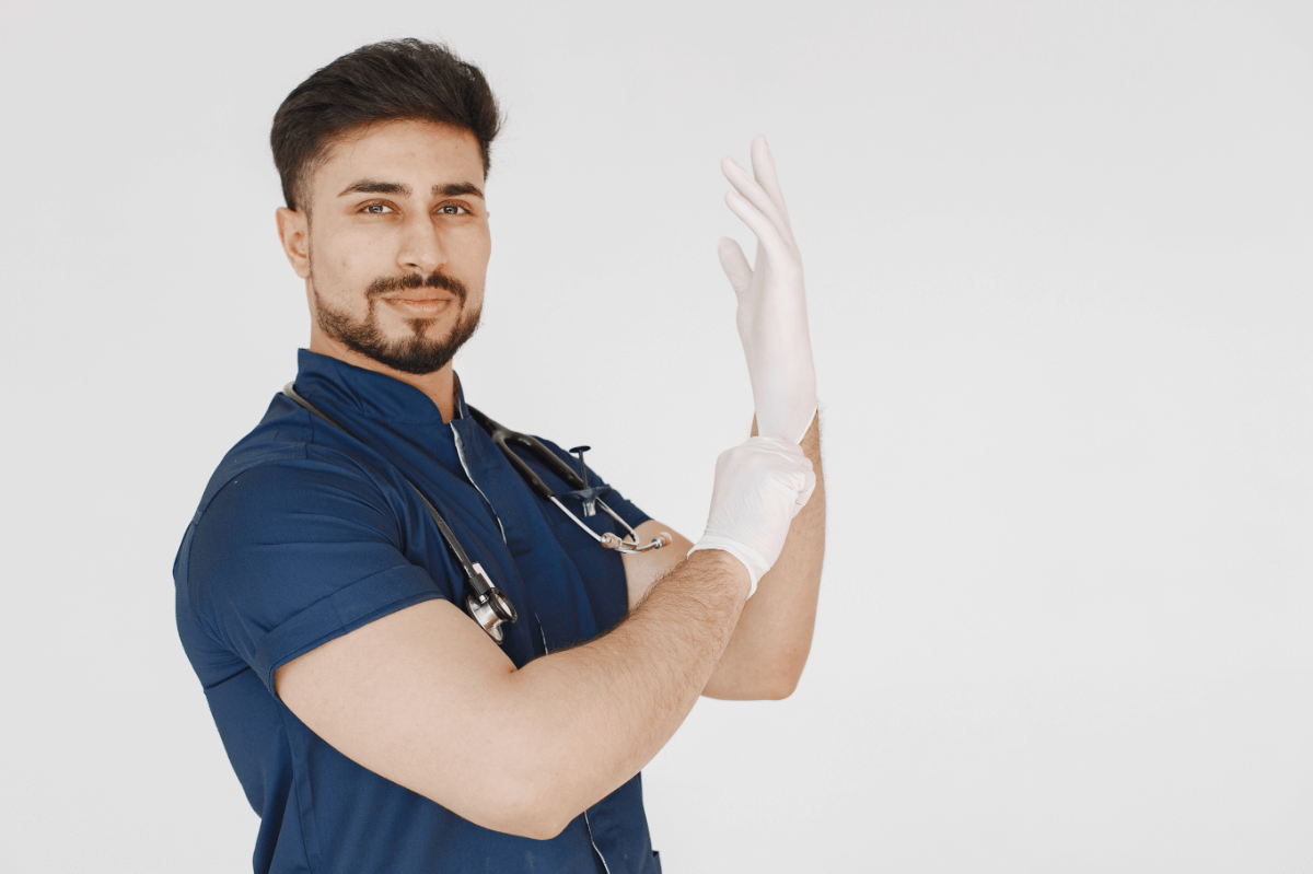 Doktorspiele Sex: Ein Mann mit Stetoskoph zieht sich weiße Gummihandschuhe an. Englisch: Doctor sex games: a man with a stethoscope puts on white rubber gloves.