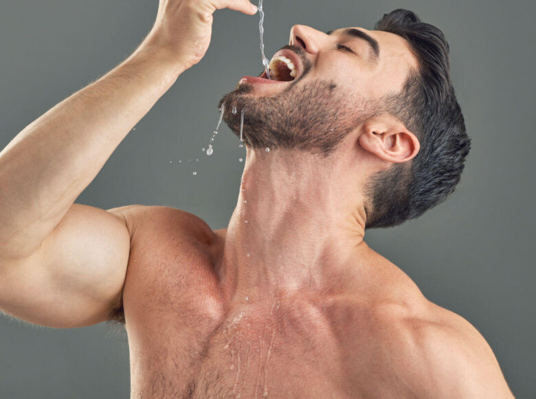 Gagging Symbolbild: Ein Mann mit nacktem Oberkörper lässt sich Wasser tief in den Hals tropfen.