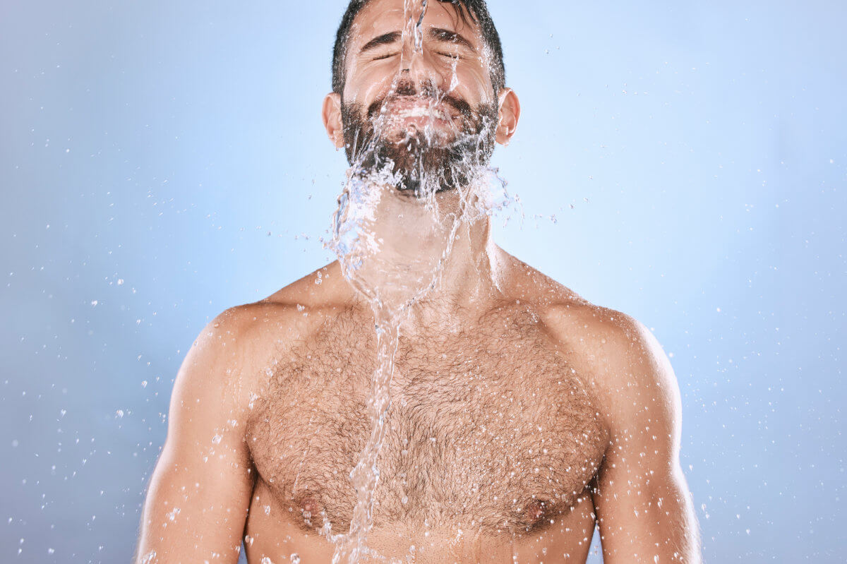 Darmspülung Symbolbil: Mann mit nacktem Oberkörper bekommt Wasser über das Gesicht geschüttet. Englisch: Bowel cleansing Symbolic image: Man with bare upper body having water poured over his face.