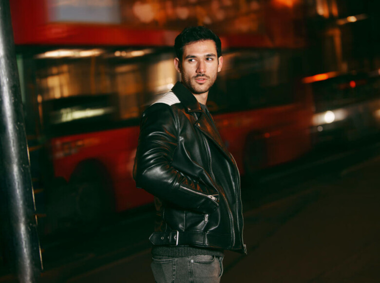 BDSM Benefits Symbolbild: Ein Mann schaut zurück richtung Kamera. Hinterhin fährt ein Bus vorbei. Englisch: BDSM benefits Symbolic image: A man looks back toward the camera. A bus drives past behind him.