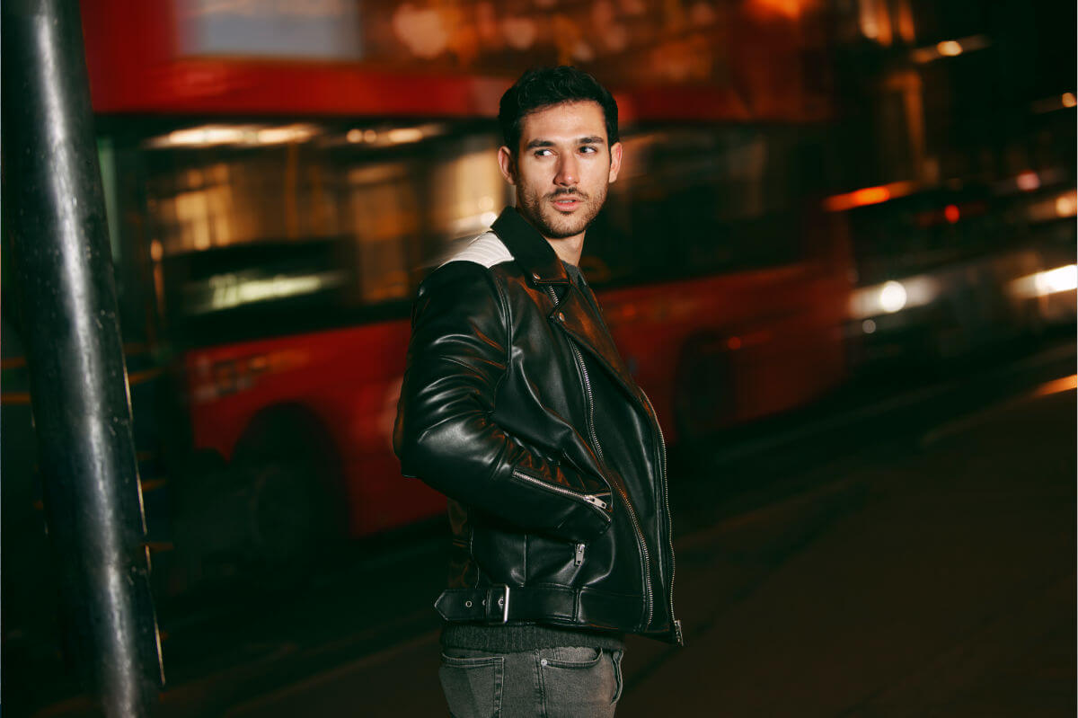 BDSM Benefits Symbolbild: Ein Mann schaut zurück richtung Kamera. Hinterhin fährt ein Bus vorbei. Englisch: BDSM benefits Symbolic image: A man looks back toward the camera. A bus drives past behind him.