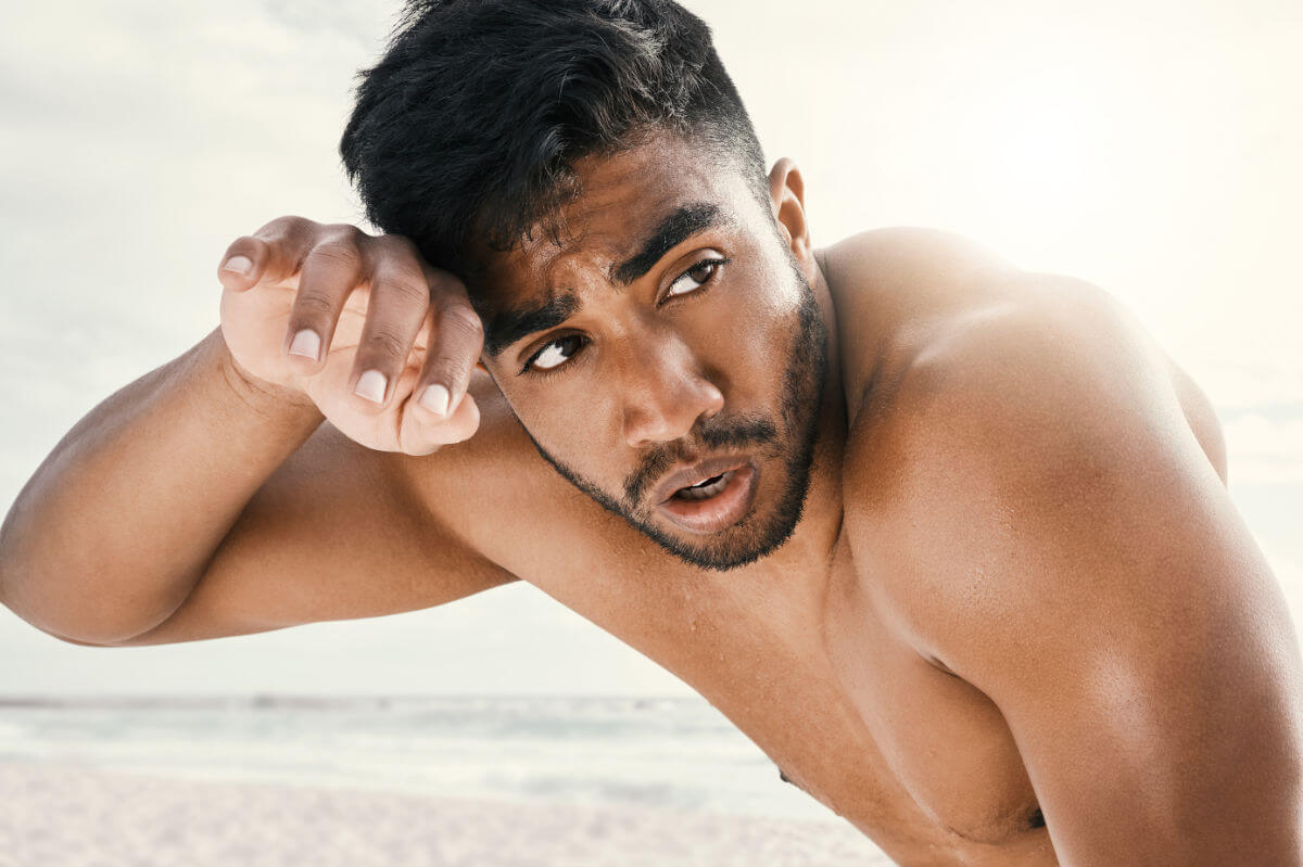 Sexgeschichte Fisting Symbolbild: Ein Mann mit nacktem Oberkörper schaut sichtlich erregt in die Kamera. Englisch: Sex story fisting Symbolic image: A man with a naked upper body looks visibly aroused at the camera.