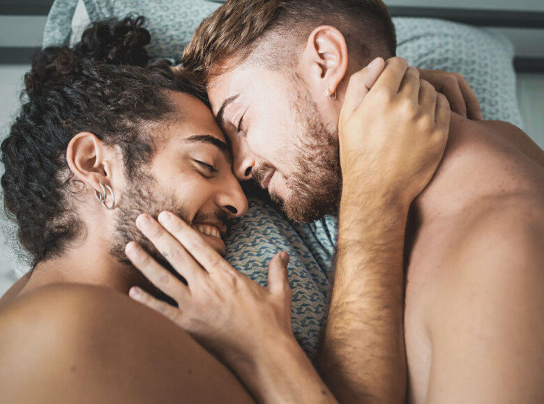 Frotting vs. Dry Humping Symbolbild: Zwei Männer liegen nackt im Bett und kuscheln. Frotting vs. Dry Humping Symbolic image: Two men lying naked in bed and cuddling.