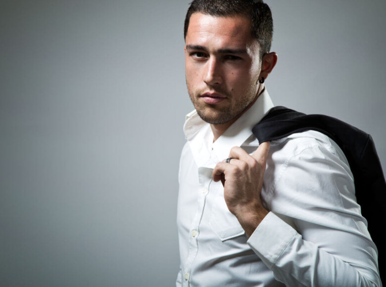 BDSM Geschichte Wenn der CEO mit seinem Assistenten “arbeitet”. Symbolbild: Ein Mann mit Hemd hat seine Anzugjacke über die Schulter gelegt. . BDSM story When the CEO “works” with his assistant. Symbolic image: A man wearing a shirt has his suit jacket draped over his shoulder.