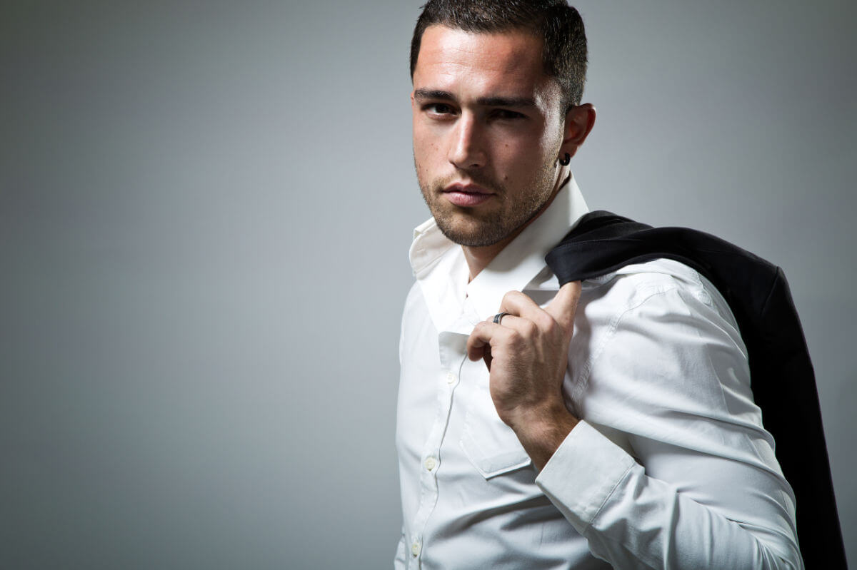 BDSM Geschichte Wenn der CEO mit seinem Assistenten “arbeitet”. Symbolbild: Ein Mann mit Hemd hat seine Anzugjacke über die Schulter gelegt. . BDSM story When the CEO “works” with his assistant. Symbolic image: A man wearing a shirt has his suit jacket draped over his shoulder.